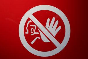 a red sign with a white circle and a hand in the middle
