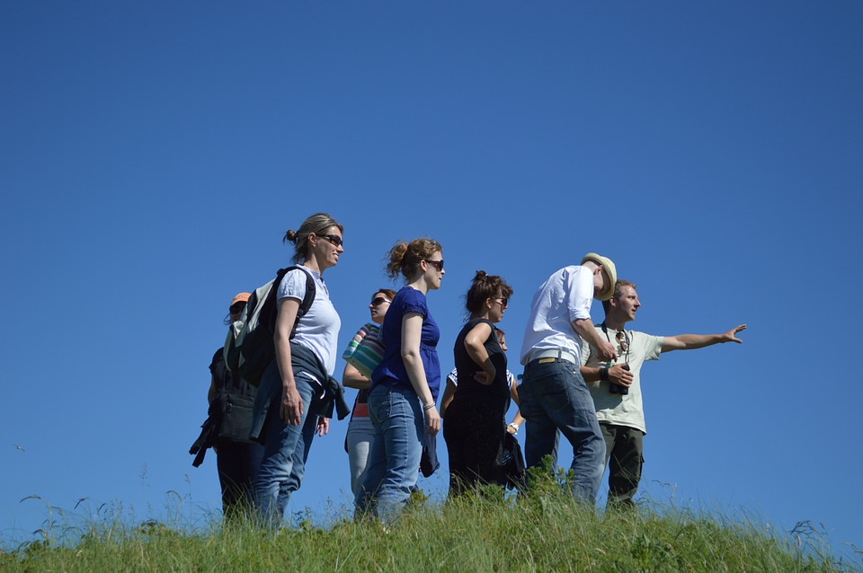 a group of people standing on a grassy hill