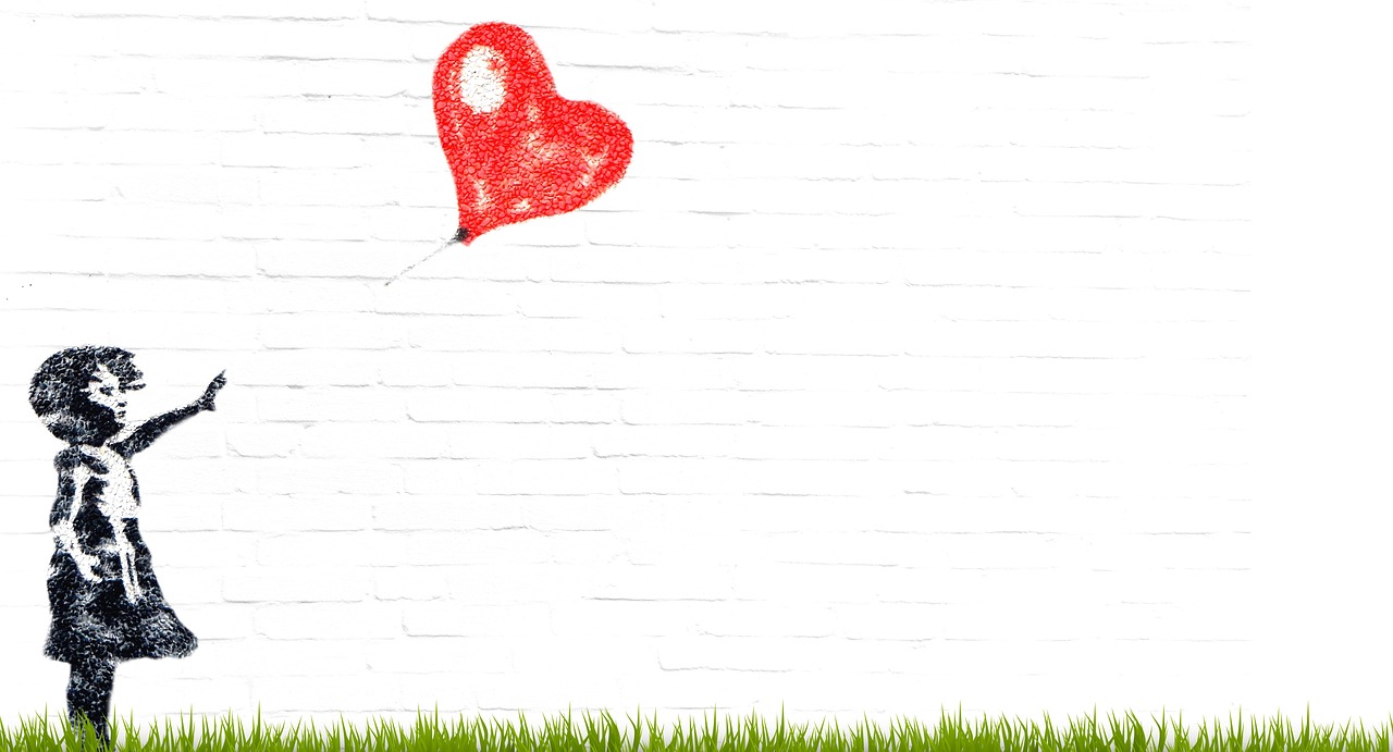 a red heart balloon drawn on a white brick wall