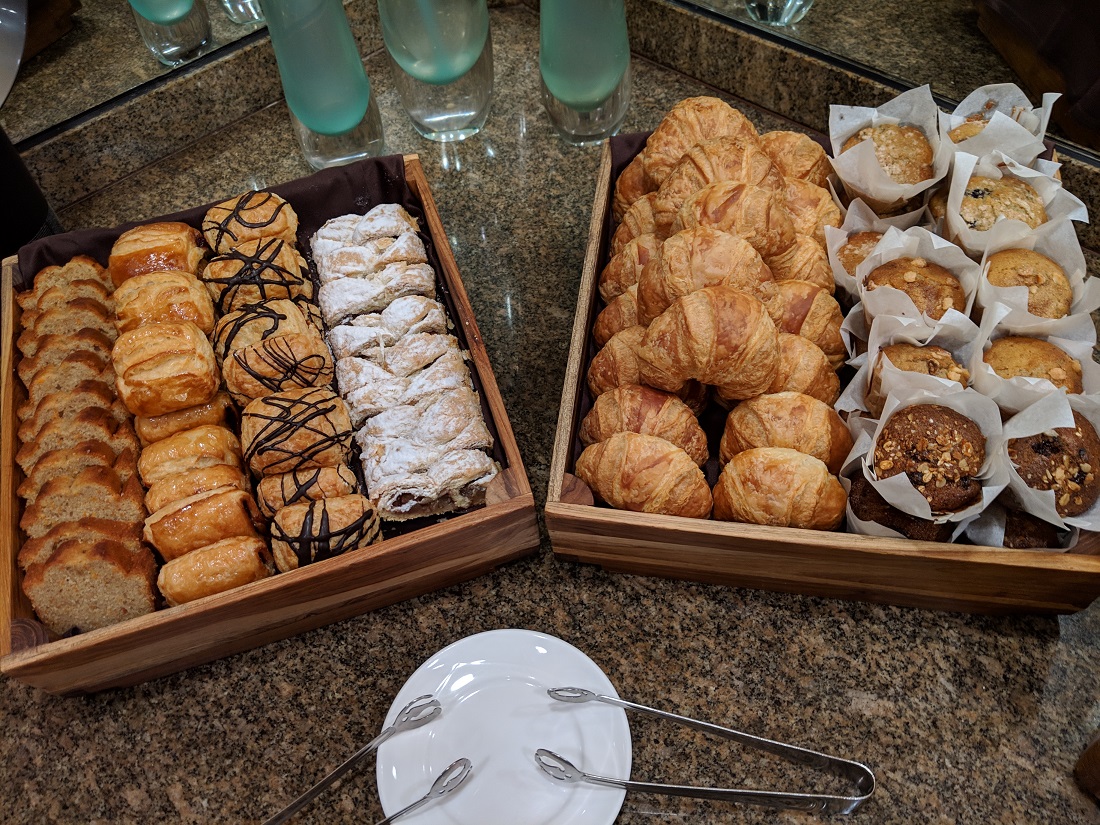 a trays of pastries and muffins on a counter