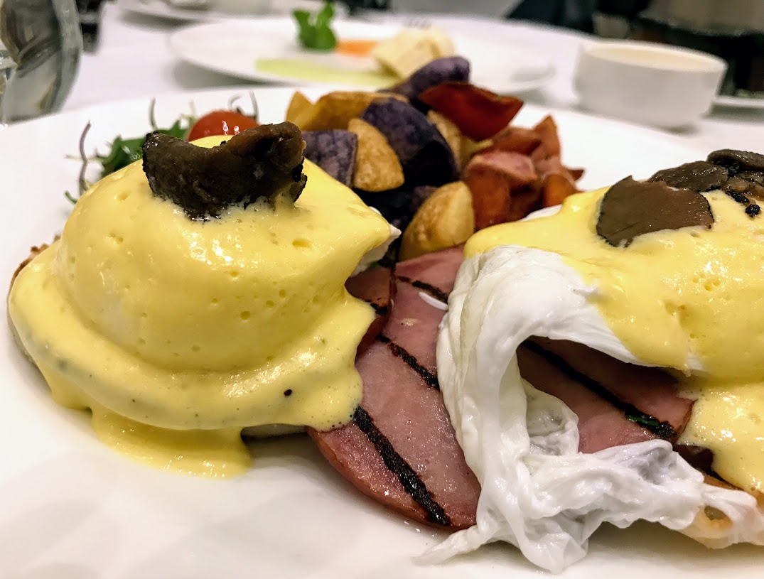 a plate of food with eggs benedict and vegetables