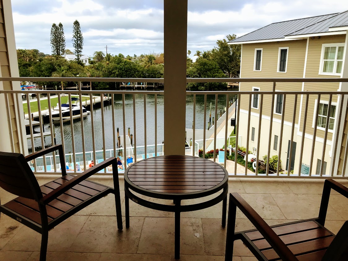 a table and chairs on a balcony overlooking a river