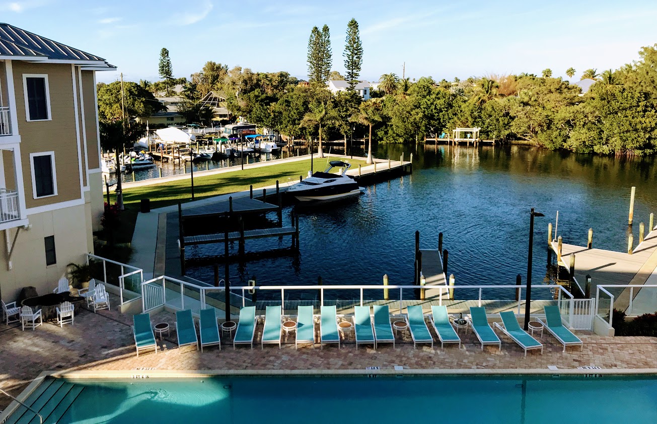 a pool with a dock and boats in the background