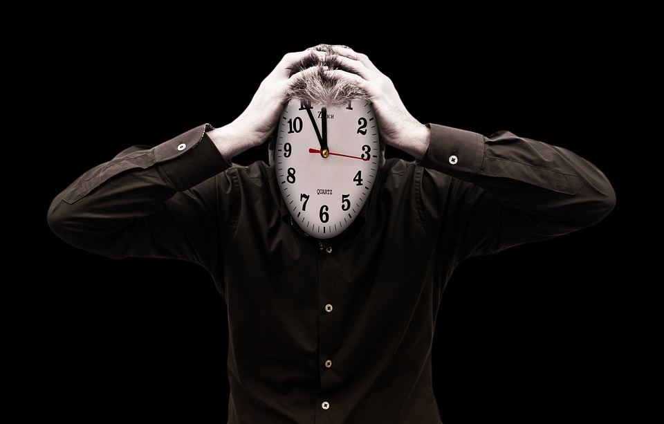 a man holding a clock over his face