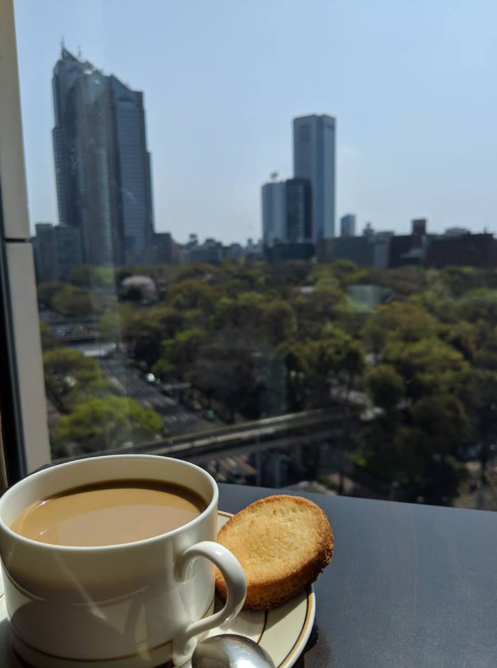 a cup of coffee and a cookie on a window sill