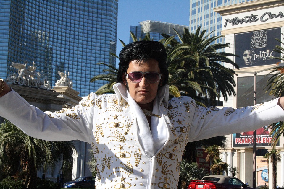 a man in a white suit with gold and black hair