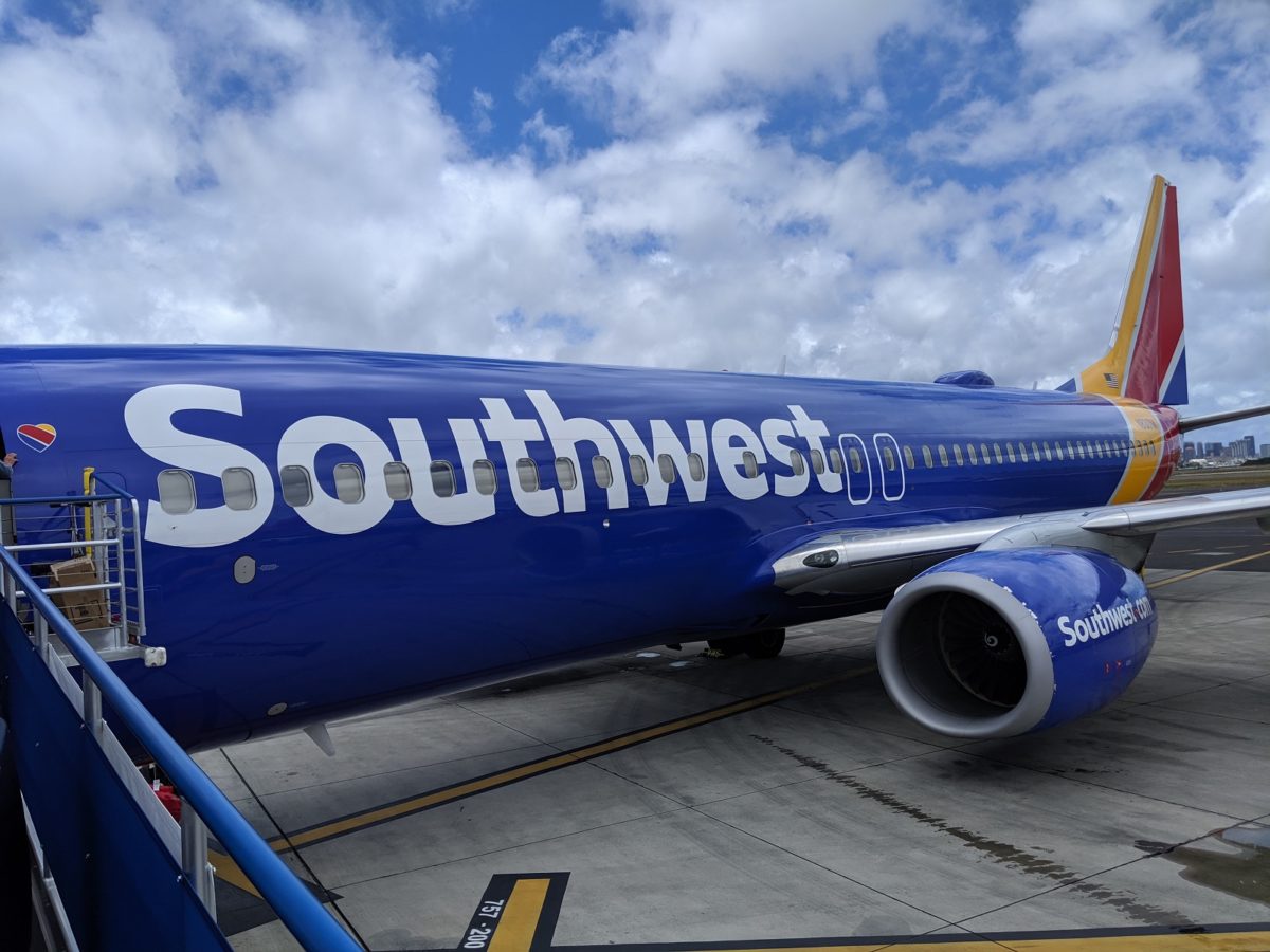 a blue airplane on a runway