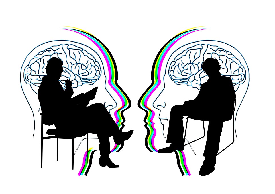 a couple of people sitting in chairs with a rainbow brain behind them