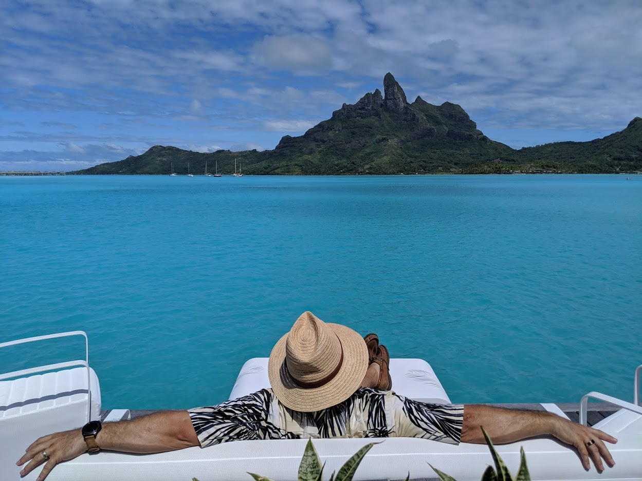 a person in a hat on a boat overlooking a body of water