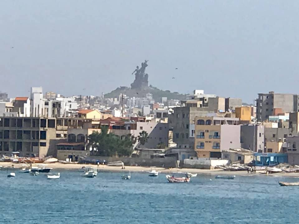 a city with a statue in the background