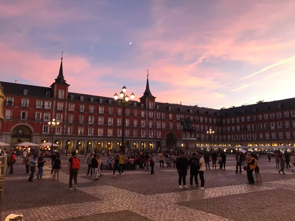 a group of people in a plaza with Plaza Mayor, Madrid in the background