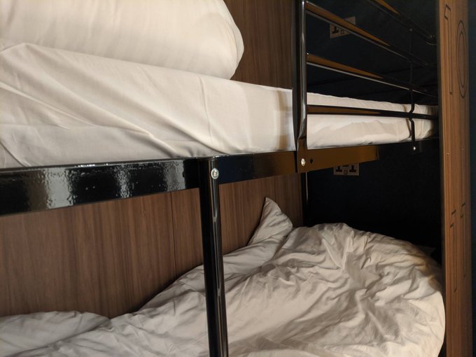 a bunk bed with white sheets