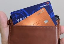 a hand holding a wallet with credit cards inside