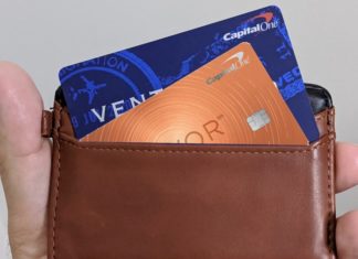 a hand holding a wallet with credit cards inside