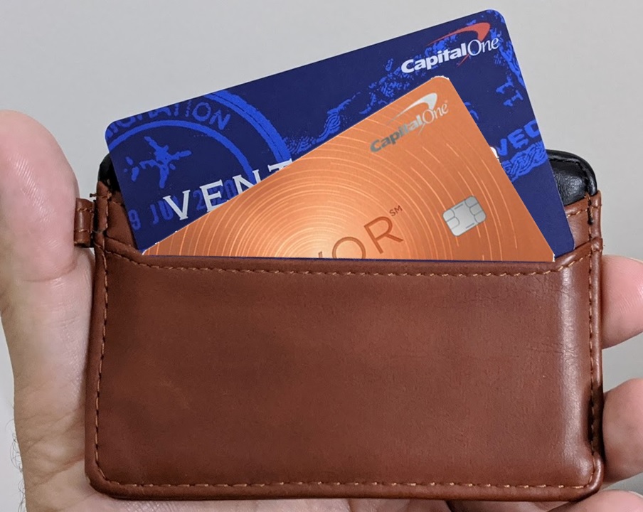a hand holding a wallet with credit cards inside