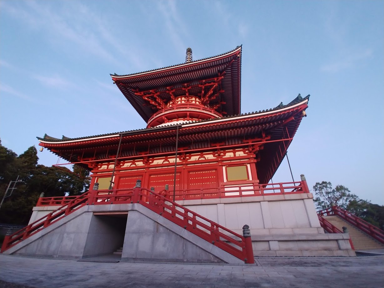 a red pagoda with a red bridge with Kiyomizu-dera in the background