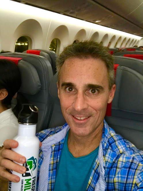 a man holding a bottle in a plane
