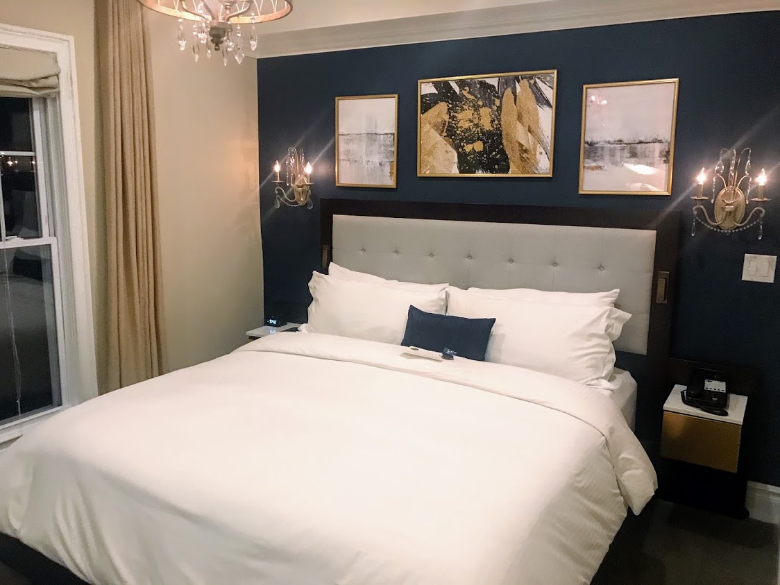 a bed with a chandelier and pictures on the wall