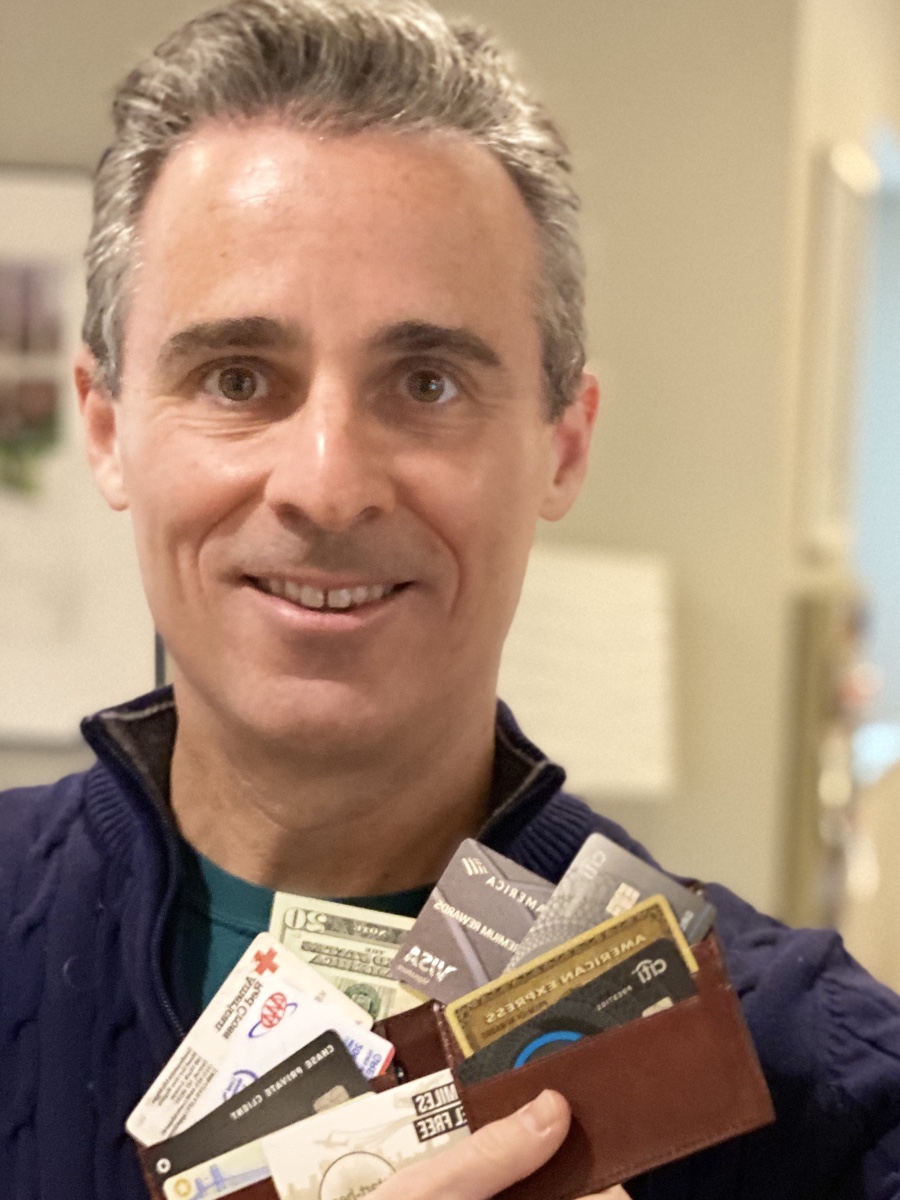 a man holding a wallet full of credit cards
