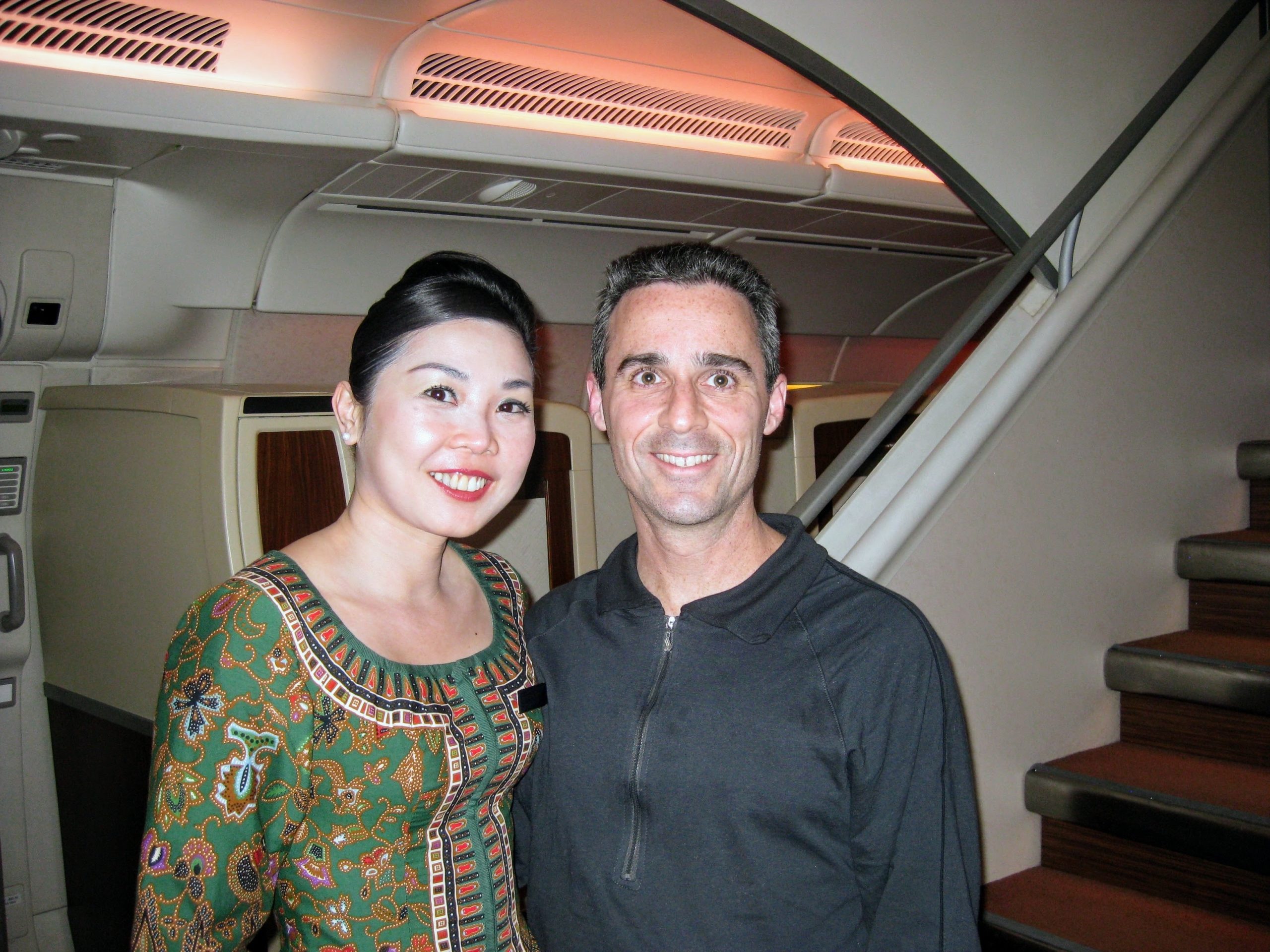a man and woman standing together in an airplane