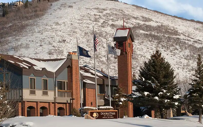 a building with flags in front of a snowy hill