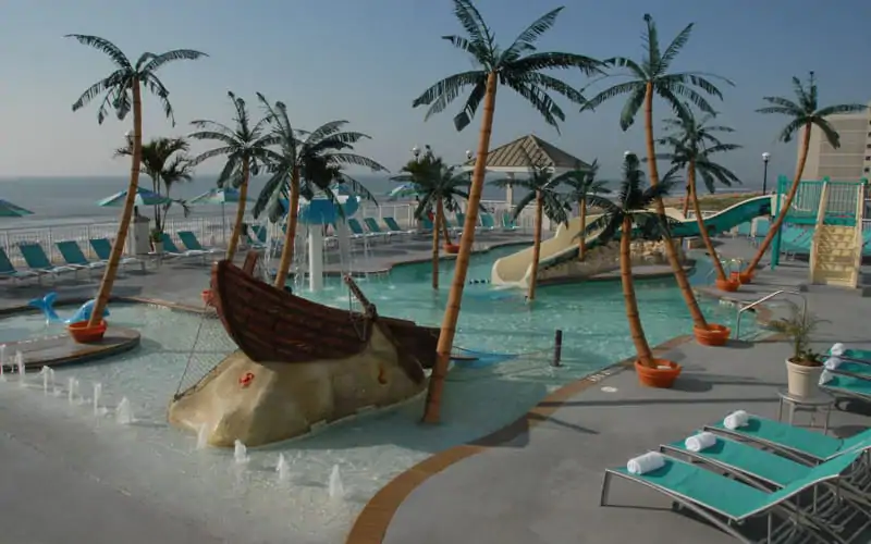 a water park with palm trees and a boat