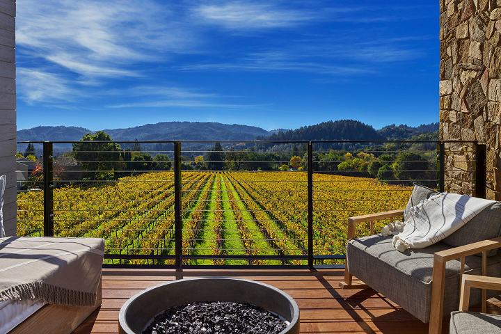 a couches on a deck overlooking a vineyard