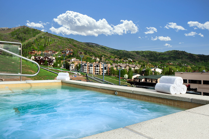 a pool with towels on it and a hill in the background