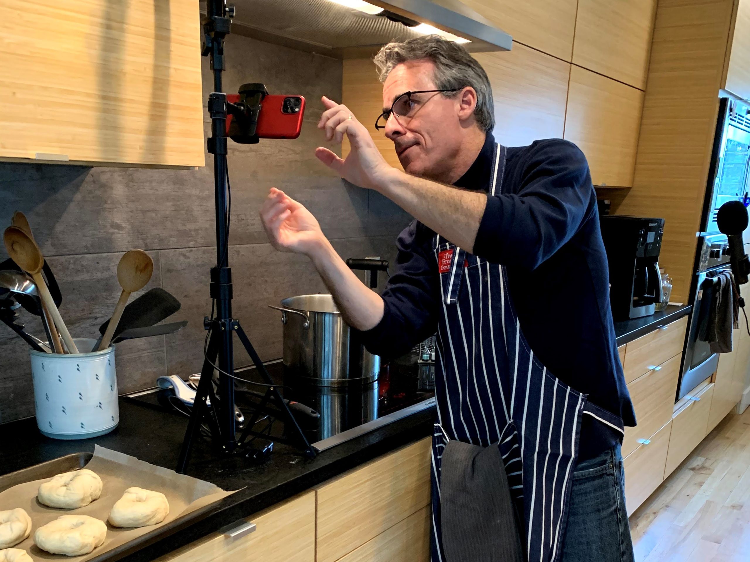 a man in a kitchen taking a picture of food