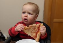 a baby eating pizza