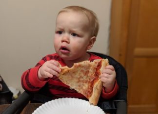 a baby eating pizza
