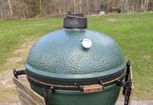 a green round grill on a stand
