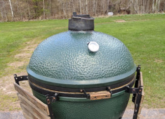 a green round grill on a stand