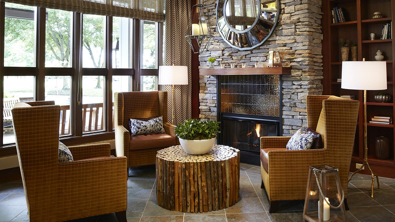 a room with a fireplace and a round mirror