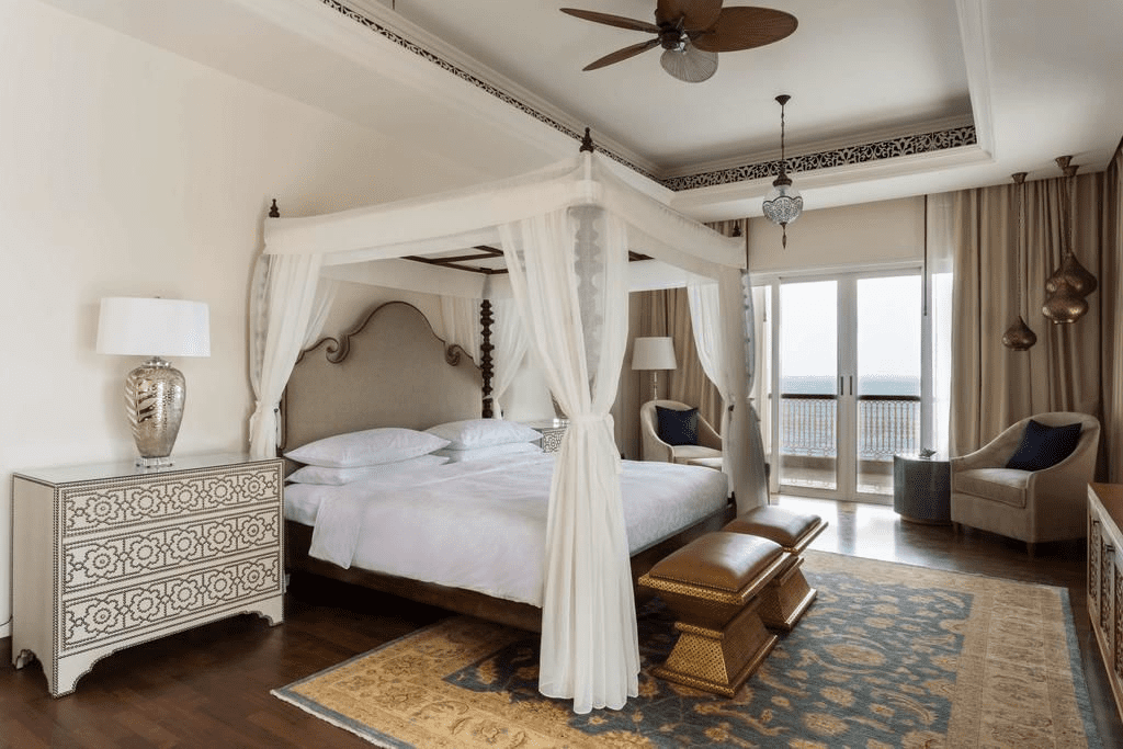 a bedroom with a four poster bed and a fan