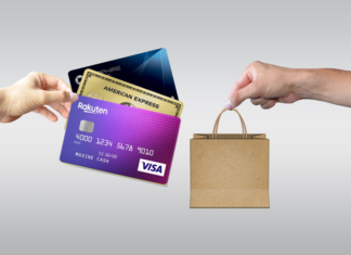 a hand holding a credit card and a bag