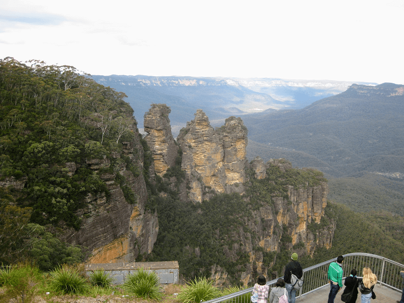 people walking on a bridge over a cliff