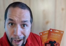 a man holding up two gift cards