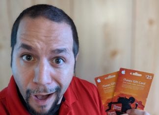 a man holding up two gift cards