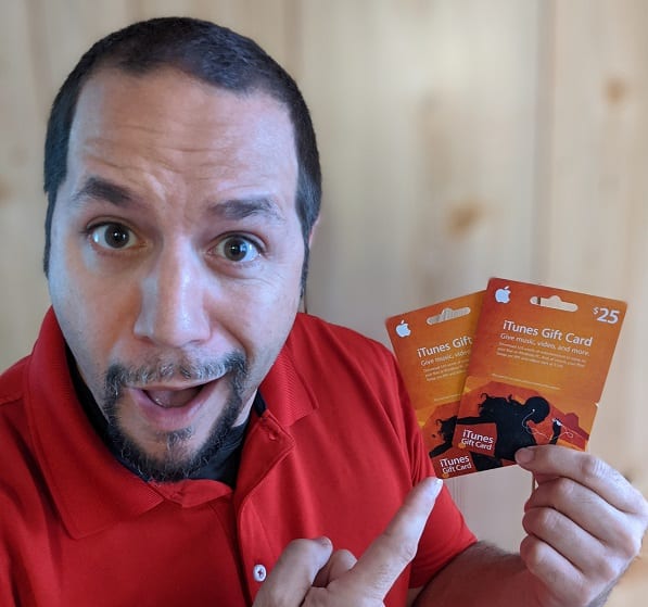 a man holding up two gift cards