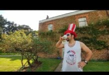 a man wearing a red white and blue hat and drinking from a cup