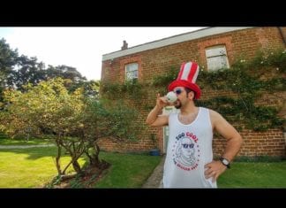 a man wearing a red white and blue hat and drinking from a cup