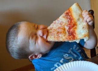 a child eating a slice of pizza