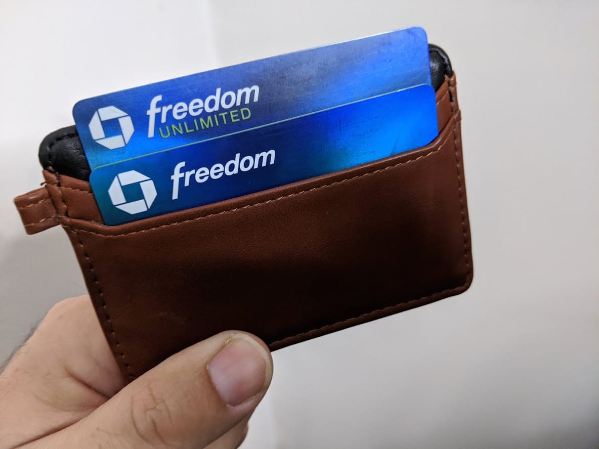 a hand holding a wallet with credit cards