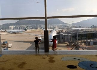 two children looking at airplanes in an airport