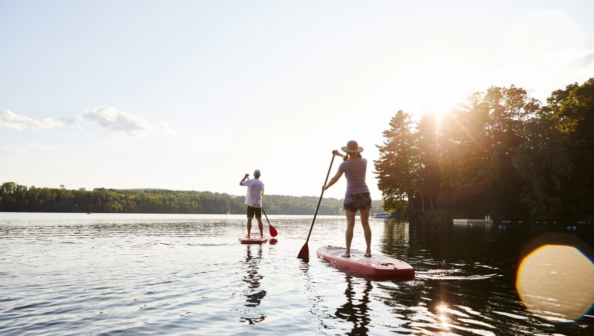 a couple of people on paddle boards on a lake