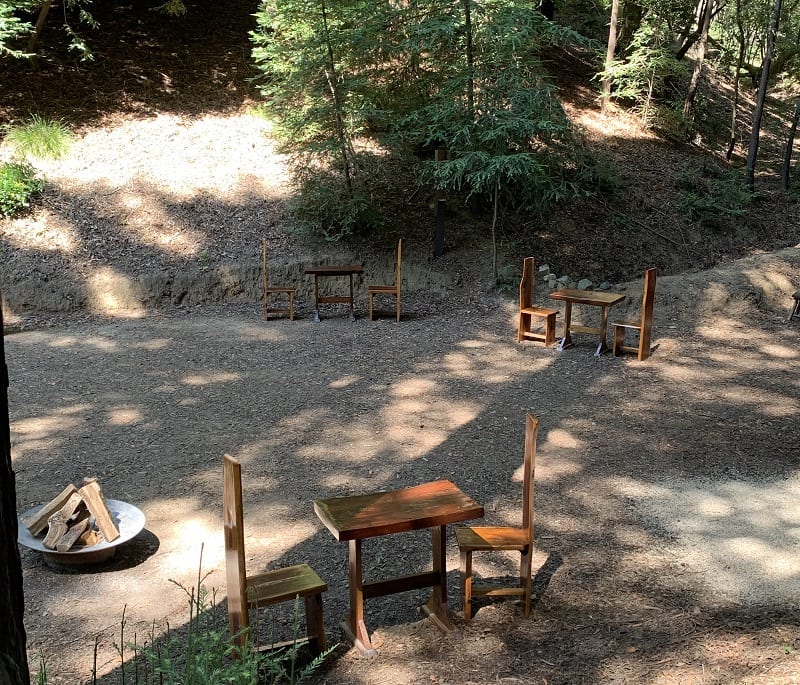 a picnic table and chairs in a forest