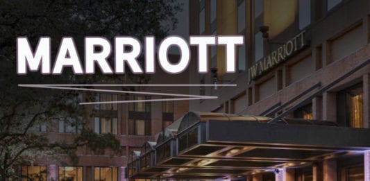 a hotel entrance with a street and a building