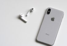 a cell phone and earbuds on a white surface