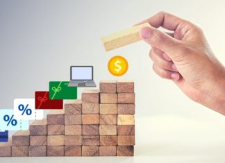 a hand placing a block on a stack of wood blocks